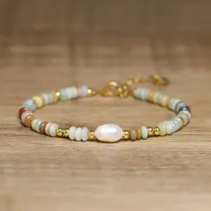 Detailed view of handmade bracelet with Baroque pearl and rainbow natural stones.