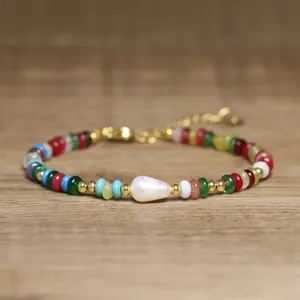 Macro detail of a colorful beaded bracelet featuring a unique Baroque pearl center