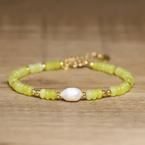 Detailed macro view of a handmade baroque pearl bracelet with elegant yellow stone beads.