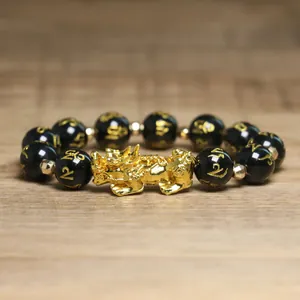 Vue détaillée des perles noires et du Pixiu doré sur un bracelet de richesse