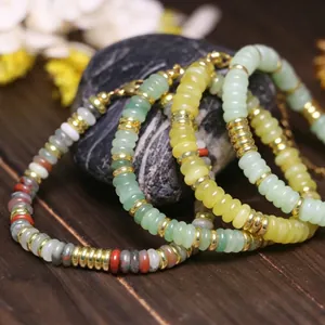Primo piano di braccialetti regolabili con perline in acciaio inox e pietre naturali di lusso.