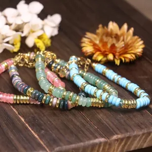 Dettaglio macro di braccialetti con perline di pietra naturale e distanziatori dorati