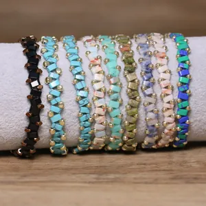 Close-up of various handmade beaded elastic bracelets with colorful stone and gold beads