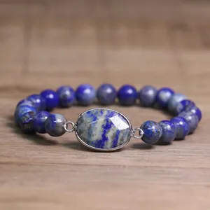 Vue détaillée d'un bracelet élastique en perles de lapis-lazuli naturel bleu sur du bois clair