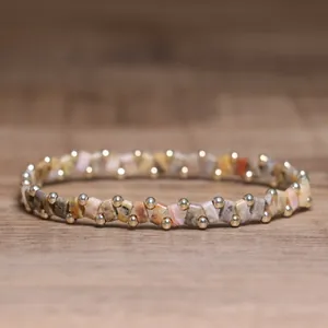 Close-up of pink handmade beaded elastic bracelet with stone chips and gold beads