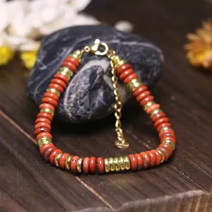 Vista dettagliata del bracciale con perle di diaspro rosso e acciaio inossidabile