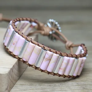 Close-up of handmade pink cylindrical stone and silver bead woven leather bracelet