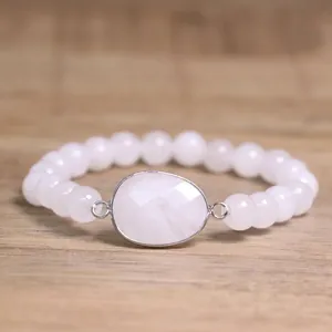 Gros plan détaillé d'un bracelet en perles de pierre naturelle blanche avec pendentif.