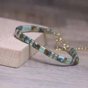 Detail view of geometric natural stone bracelet with gold spacers and extension chain