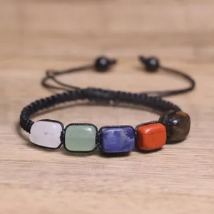 Dettaglio delle pietre naturali dei chakra su un braccialetto yoga nero intrecciato regolabile