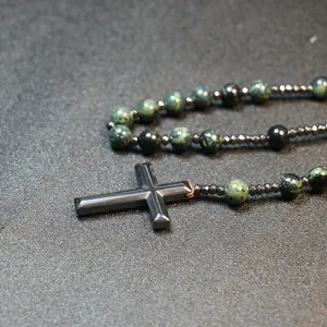 Close-up detail of a men hematite cross pendant necklace with natural green jasper stone beads
