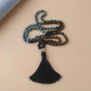 Détail d'un collier mala de 108 perles avec œil de tigre et pierres de lave noires