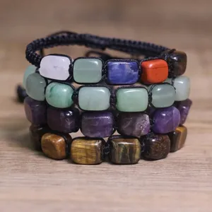 Primo piano di braccialetti chakra intrecciati con varie perline di pietra naturale