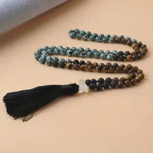 Détail d'un collier de 108 perles Mala en œil de tigre et pierre de lave avec pompon noir