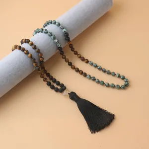 Détail de 108 perles mala en pierre naturelle avec œil de tigre, pin africain et pompon.