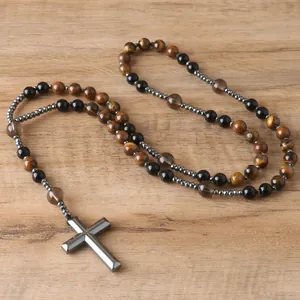 Close-up detail of natural tiger eye beads and hematite cross pendant on a rosary