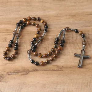 Detail of a tiger eye and hematite bead rosary necklace featuring a large cross pendant.