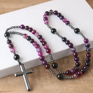 Detail of natural purple agate beads and hematite cross pendant on rosary necklace