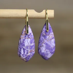 Close-up of elegant purple imperial stone teardrop earrings with polished gold hooks