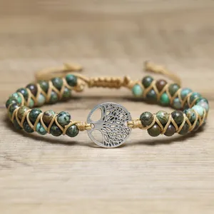 Macro detail of Tree of Life charm and natural African Turquoise beads on woven bracelet.