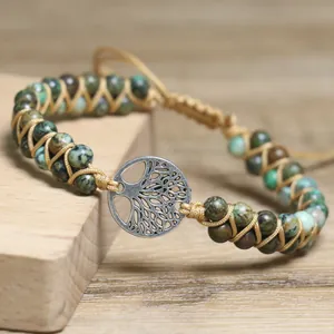 Macro view of African turquoise beads and silver tree of life charm on woven bracelet