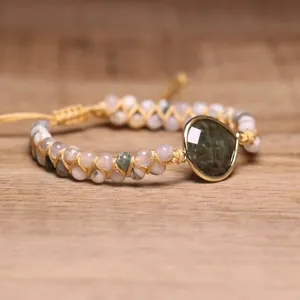 Detail van handgevlochten dubbellaagse armband met labradoriet en boomagaat