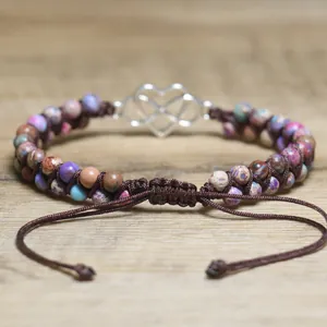 Detailed macro view of hand-woven colorful stone beaded bracelet with heart infinity charm