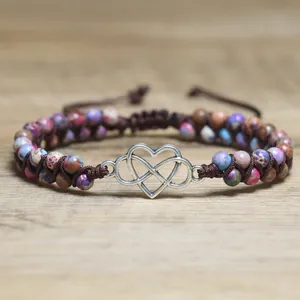Close-up of a double-layered braided bracelet with colorful jasper beads and heart charm
