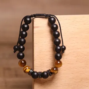 Detailweergave van handgemaakte verstelbare armband met tijgeroog en zwarte kralen