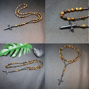 Primer plano de cuentas de ojo de tigre y colgante de cruz de hematita en un collar Mala