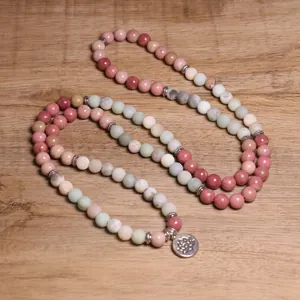 Dettaglio di una collana da 108 perle in pietra multicolore con ciondolo floreale in argento