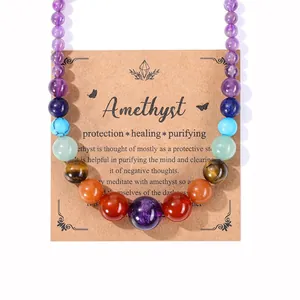 Nahaufnahme einer bunten Naturstein-Perlenkette auf einer Amethyst-Heilkarte für Schmuck.