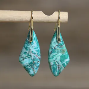 Detalle de pendientes vintage en forma de abanico con texturas de piedra natural