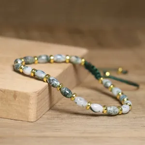 Detailed view of handmade moss agate beads with golden spacers and adjustable cord