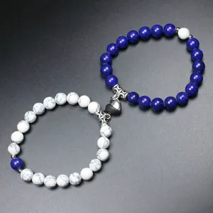 Primo piano della chiusura magnetica a cuore tra braccialetti in perline di pietra.