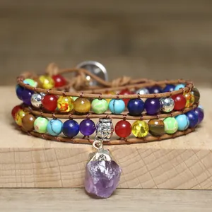 Detailed view of bohemian multi-colored stone wrap bracelet with raw amethyst pendant.