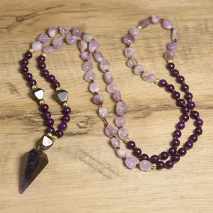 Detail van een handgemaakte amethist mala ketting met paarse kralen en een hanger.