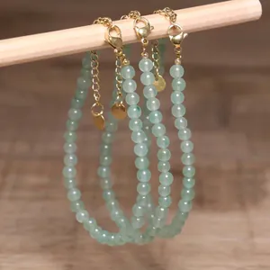 Close-up detail of green aventurine beaded necklaces with gold-tone extension chains