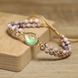 Détail du charm opale goutte et des perles de pierre zébrée rose sur bracelet tissé