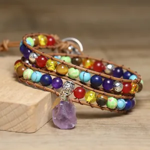 Macro view of bohemian wrap bracelet with colorful beads and raw amethyst pendant