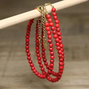 Macro view of red turquoise beaded necklace featuring gold-plated extension chain detail