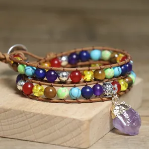 Macro detail of Bohemian wrap bracelet with colorful stone beads and raw amethyst pendant