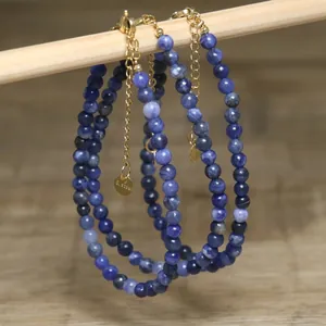 Macro view of blue natural stone beaded necklaces with gold stainless steel chains