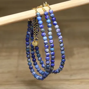 Macro detail of blue lapis lazuli beaded necklace with gold stainless steel chain