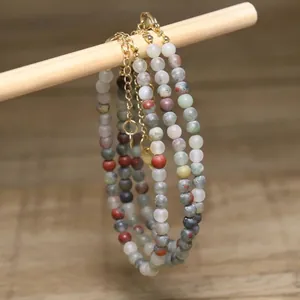 Close-up of handmade natural green aventurine and white turquoise beaded necklaces.