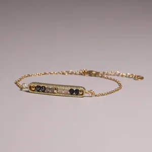 Detailed close-up view of gold-plated bar bracelet with natural citrine and hematite beads