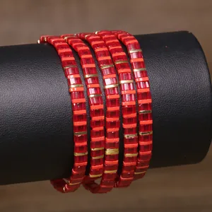 Detailed macro view of a handmade red Tila bead wrap bracelet with golden spacers