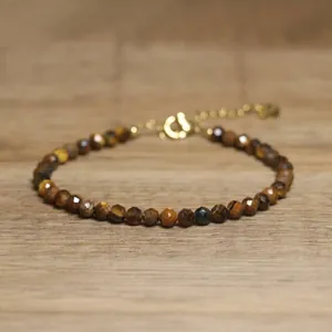 Detailed macro view of faceted brown natural stone beads on a dainty gold bracelet