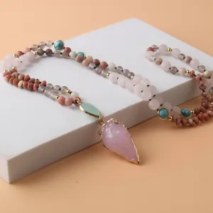 Vue détaillée d'un pendentif pointe de flèche en quartz rose sur un collier de 108 perles