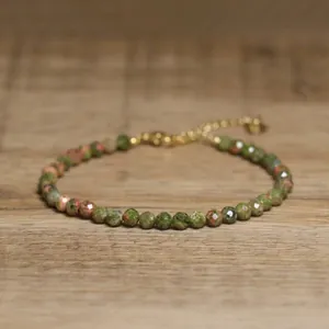 Detailed macro view of faceted African Pine natural stone beads on a gold adjustable bracelet